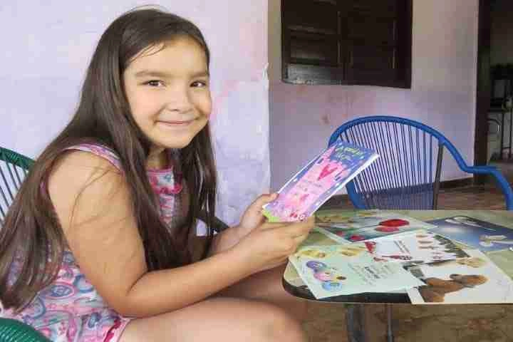 Girl holding a greeting card and smiling