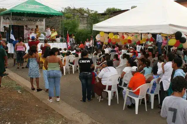 A gathering of people seated and watching a children's group perform on stage