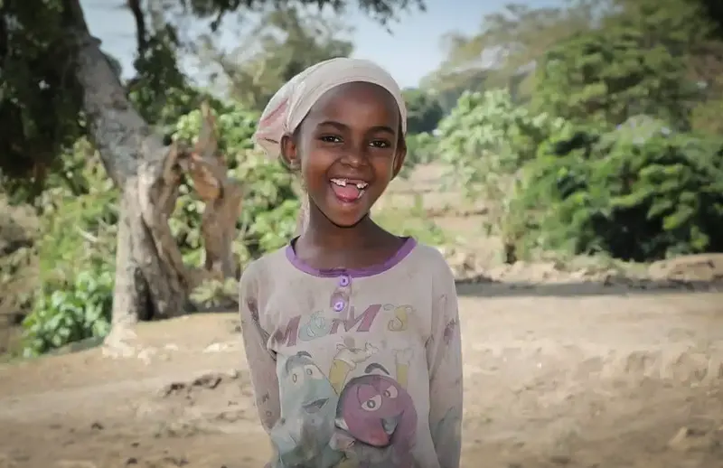 Young girl smiling and standing outside